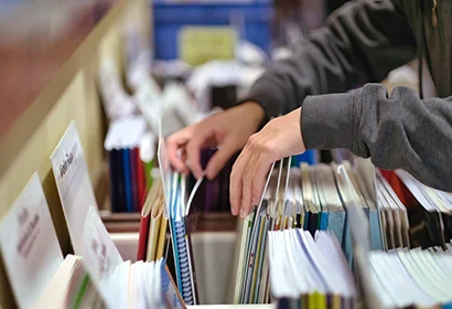 A person examining a stack of papers closely.